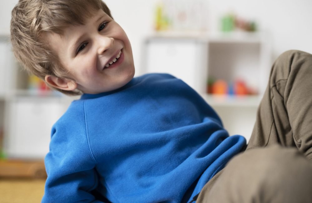 medium-shot-smiley-boy-sitting-indoors